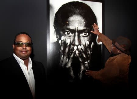 Vince Wilburn Jr. (R), looks at a photo of his uncle as Erin Davis, son of legendary jazz artist Miles Davis poses prior to the opening an exhibition "We Want Miles": Miles Davis vs Jazz, at the Montreal Museum of Fine Arts in Montreal, April 29, 2010. REUTERS/Christinne Muschi