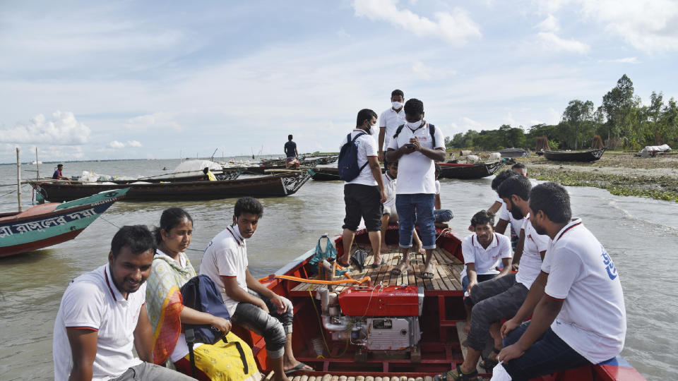 In this photo provided by Bidyanondo Foundation, doctors and health workers arrive at a village in Chandpur district in eastern Bangladesh, on Sept. 12, 2020. A Bangladeshi charity has set up a floating hospital turning a small tourist boat into a healthcare facility to provide services to thousands of people affected by this year's devastating floods that marooned millions. (Bidyanondo Foundation via AP)