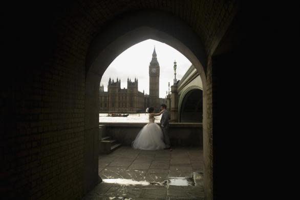 Newlyweds pose for photographs underneath Westminster Bridge in London March 10, 2012.