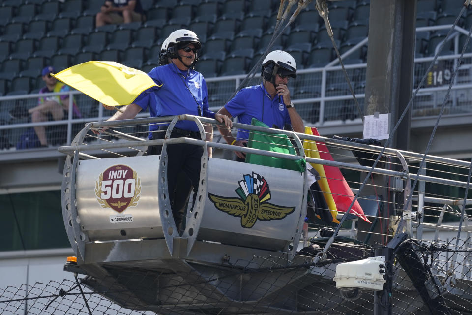 An official hold the yellow flag as it blows in the wind during practice for the Indianapolis 500 auto race at Indianapolis Motor Speedway, Friday, May 20, 2022, in Indianapolis. (AP Photo/Darron Cummings)