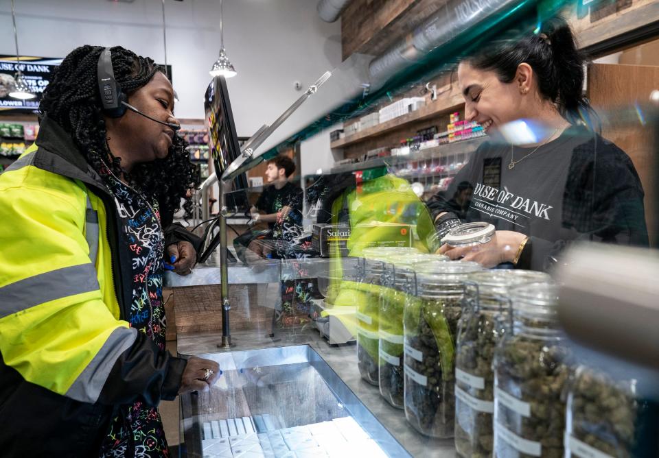Trina Jewell, 58, of Toledo, left, purchases recreational marijuana flower with the help of House of Dank general manager Crystal Jamo, 29, in Detroit on  Jan. 4, 2023, at the dispensary on Fort Street in Detroit. After years of delay, recreational marijuana finally goes on sale in Detroit. Jewell, who holds a medical marijuana card, was happy for Detroit to sell recreational marijuana products too "this is good for those that donÕt hold medical cards and it really offers more choices," said Jewell.