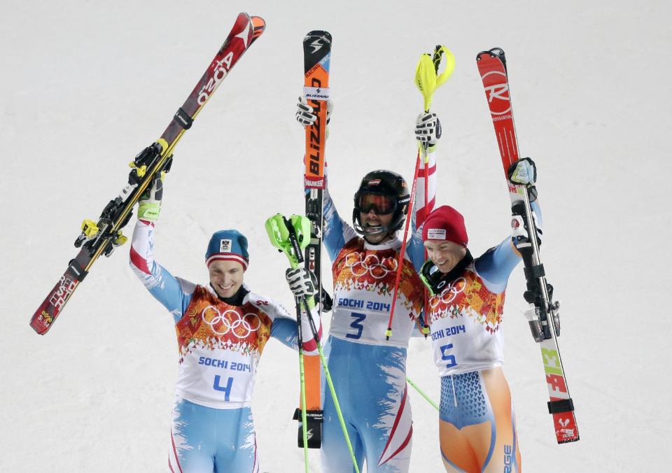 Men's slalom winners, from left Austria's Marcel Hirscher (silver), Austria's Mario Matt (gold) and Norway's Henrik Kristoffersen (bronze) celebrate at the Sochi 2014 Winter Olympics, Saturday, Feb. 22, 2014, in Krasnaya Polyana, Russia. (AP Photo/Charlie Riedel)