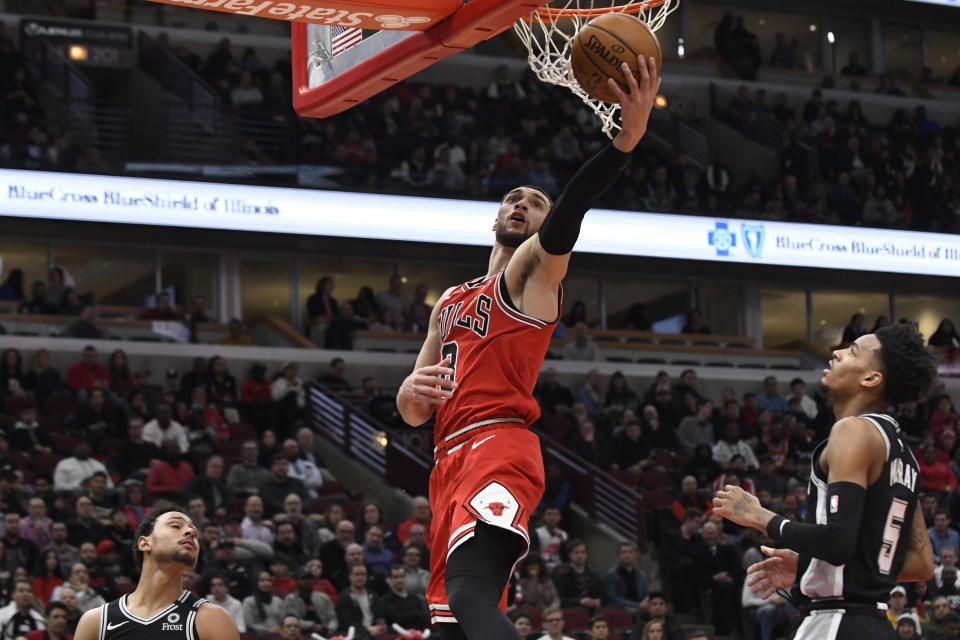 Chicago Bulls guard Zach LaVine (8) goes to the basket as San Antonio Spurs guard Dejounte Murray (5) and guard Bryn Forbes, left, defend him during the first half of an NBA basketball game Monday, Jan. 27, 2020, in Chicago. (AP Photo/David Banks)