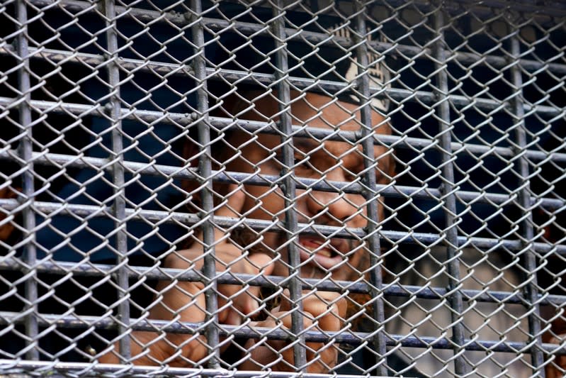 Accused of Holey Artisan Bakery attack are seen inside a prison van as they are taken out of the court after hearing a verdict in Dhaka