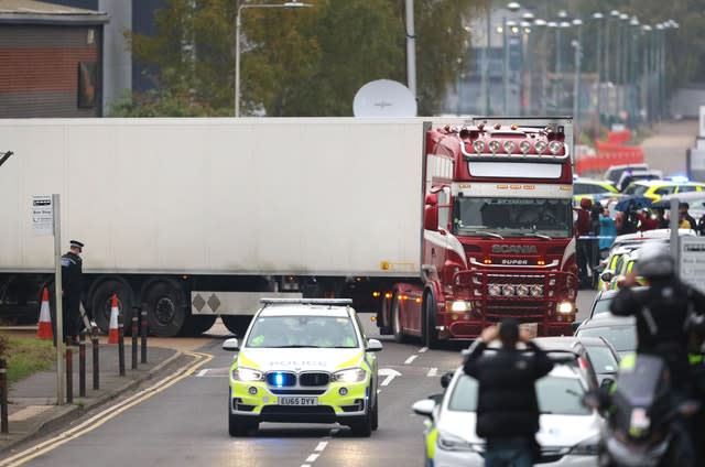 A lorry with attached container drives under police escort