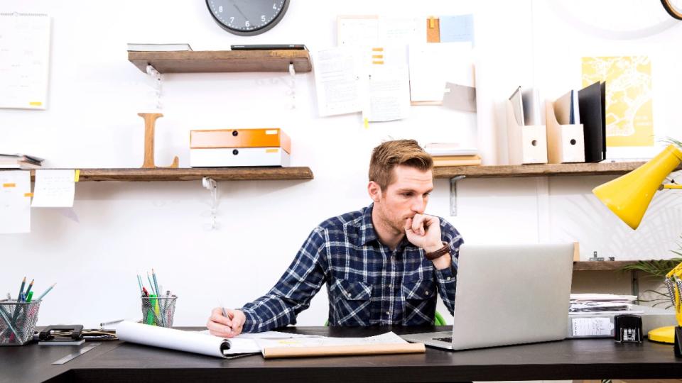 Man sitting at desk with laptop and documents