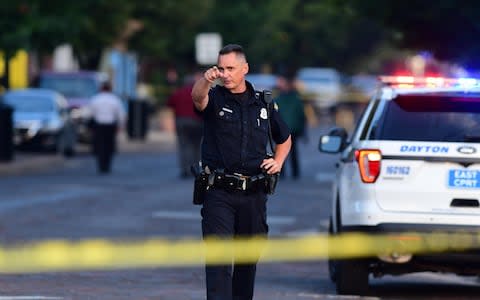  Police officers at the crime scene in Dayton, Ohio - Credit: Tom Russo/ EPA