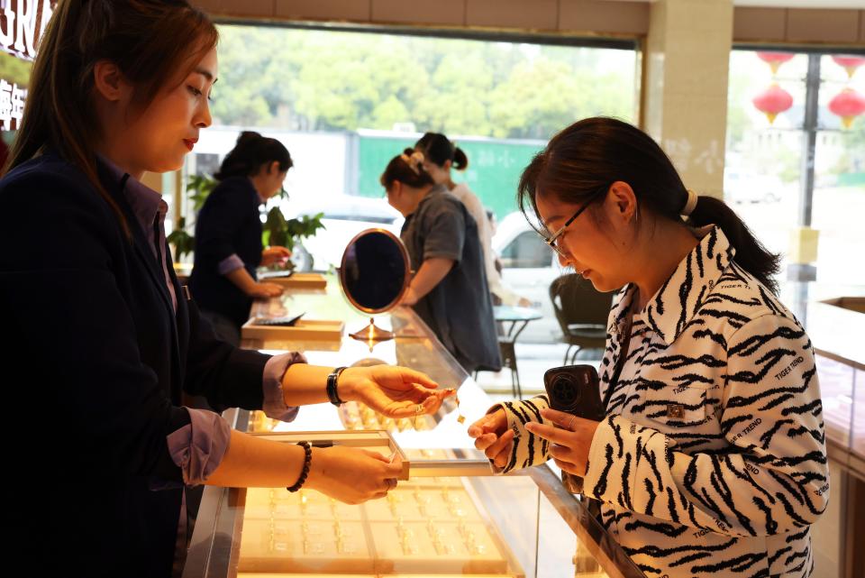 Customers select gold ornaments at a gold jewelry store on April 3, 2024 in Huzhou, Zhejiang province, China.