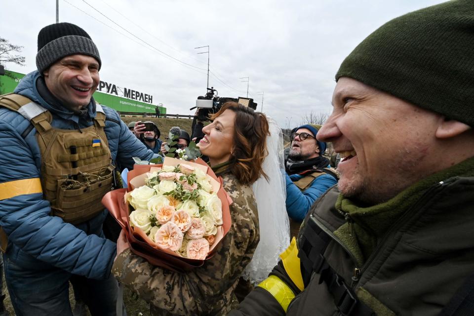 Kyiv mayor Vitali Klitschko congratulates Ukrainian territorial defense members, Valerii Fylymonov and Lesia Ivashchenko, after their wedding near a check-point on the outskirts of Kyiv on March 6, 2022.