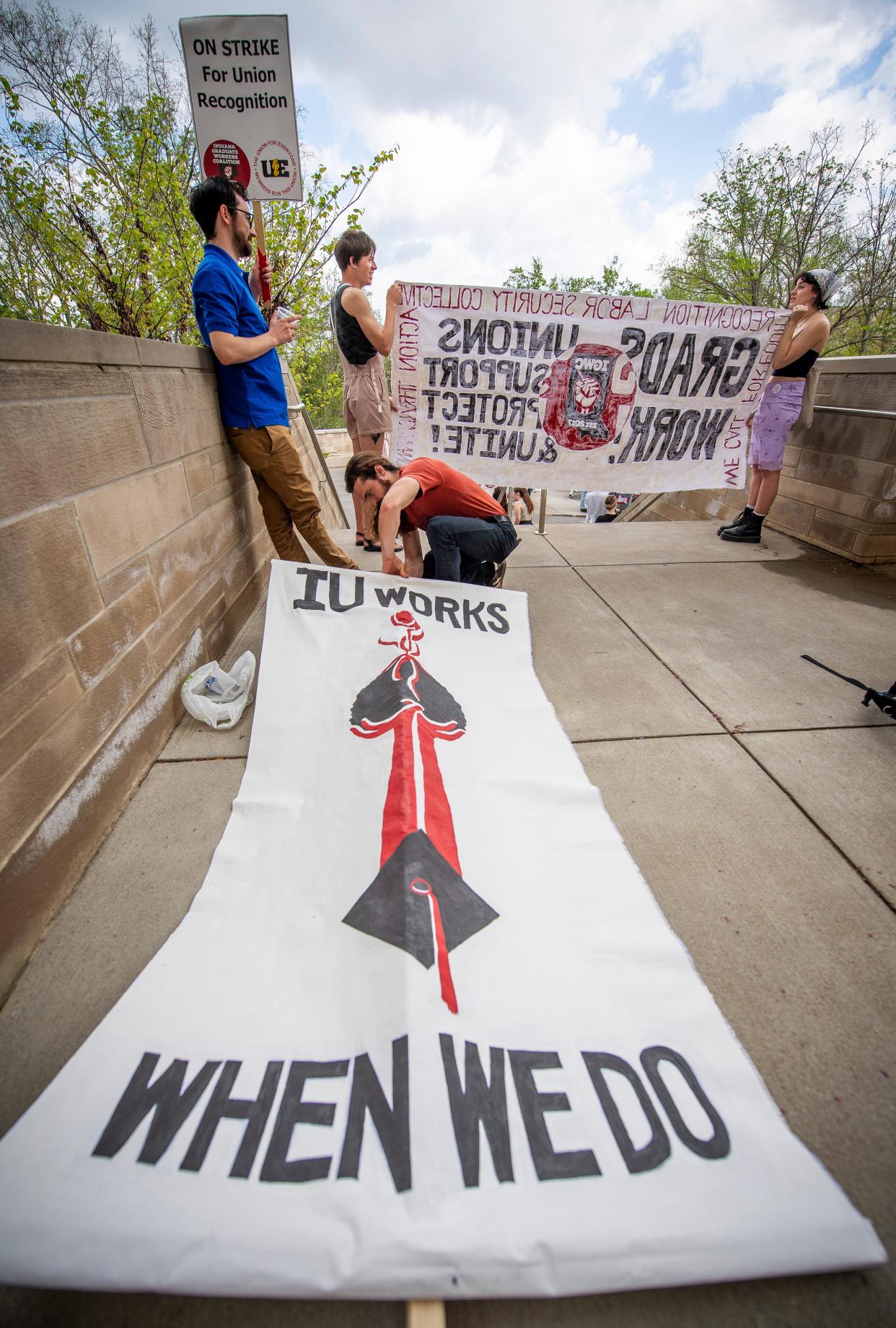 Indiana University graduate student Francisco Ormaza puts together a sign outside of Ballentine Hall on campus during an Indiana Graduate Workers Coalition-organized strike on Wednesday.