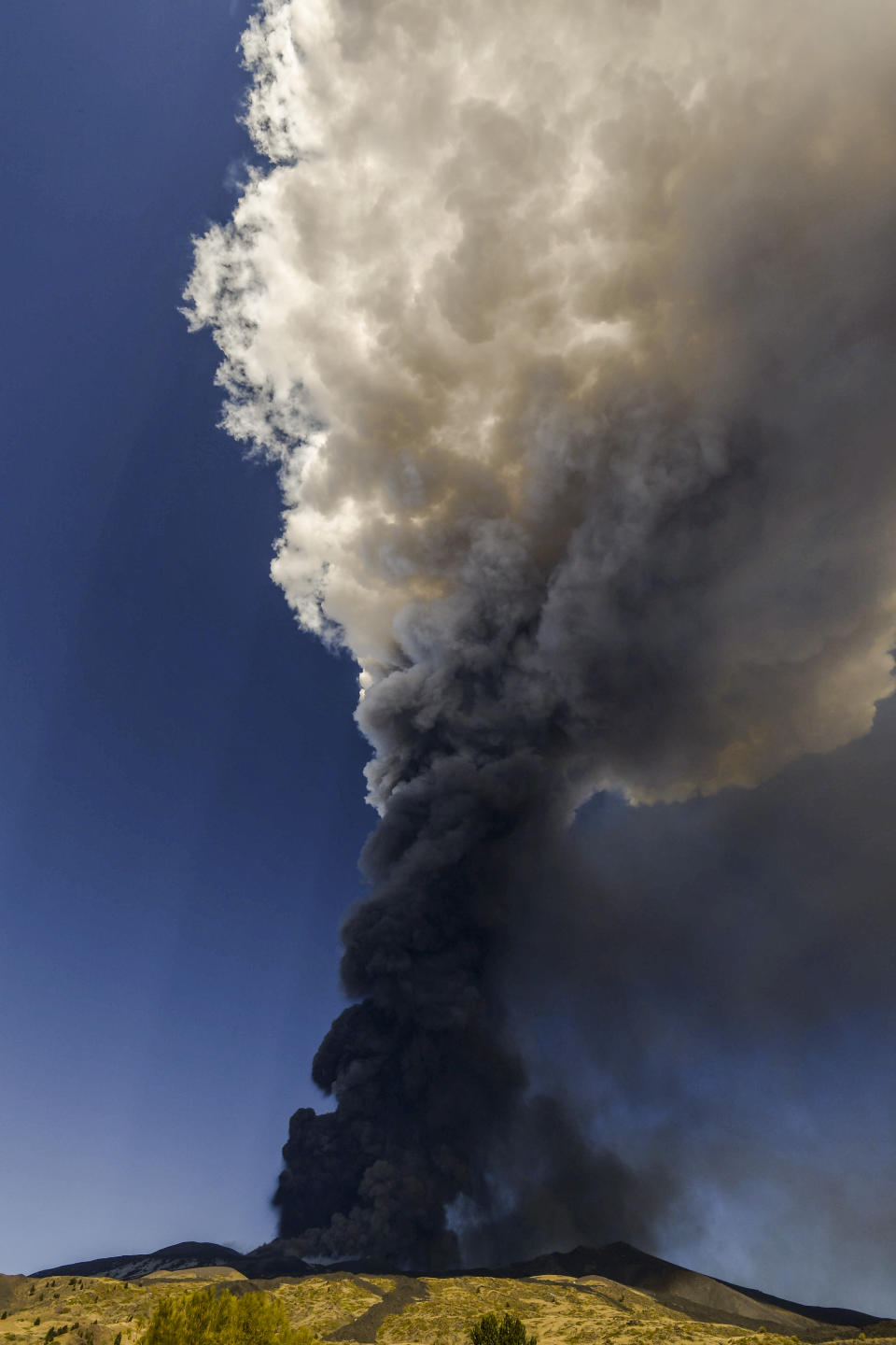 Volcanic ashes ascend from the south-east crater of the Mt. Etna volcano in Sicily, Italy, Monday, Feb. 21, 2022. The second-strongest paroxysm of 2022 produced volcanic smoke and ashes that rose for 10 kilometers (6.2 miles) forcing the temporary closure of the nearby Vincenzo Bellini international airport in Catania. (AP Photo/Salvatore Cavalli)