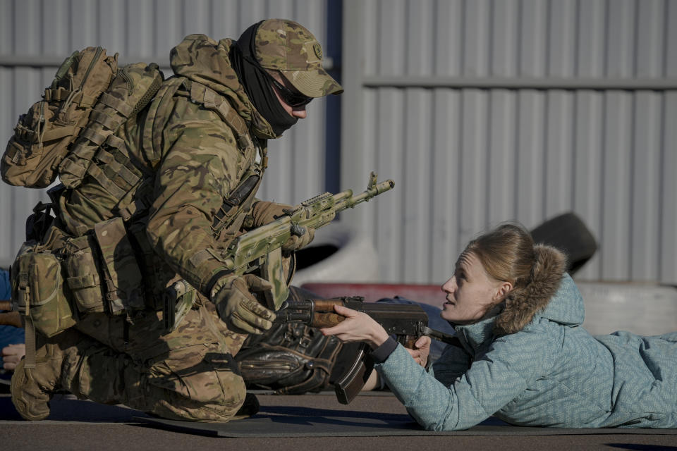 FILE - A young woman holds a weapon during a basic combat training for civilians, organized by the Special Forces Unit Azov, of Ukraine's National Guard, in Mariupol, Donetsk region, eastern Ukraine, on Feb. 13, 2022. The Ukrainian forces who made a determined last stand in a Mariupol steel mill against Russian troops were a mixture of seasoned soldiers, border guards, a controversial national guard regiment and volunteers who took up arms in the weeks before Russia's invasion. (AP Photo/Vadim Ghirda, File)