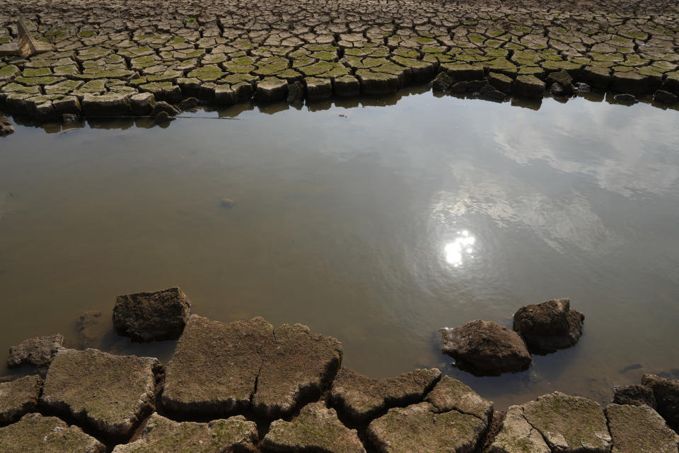 Parched earth frames the remainder of a tributary on a dried arid stretch of the Poyang Lake in north-central China's Jiangxi province on Monday, Oct. 31, 2022. A prolonged drought since July has dramatically shrunk China’s biggest freshwater lake, Poyang. (AP Photo/Ng Han Guan)