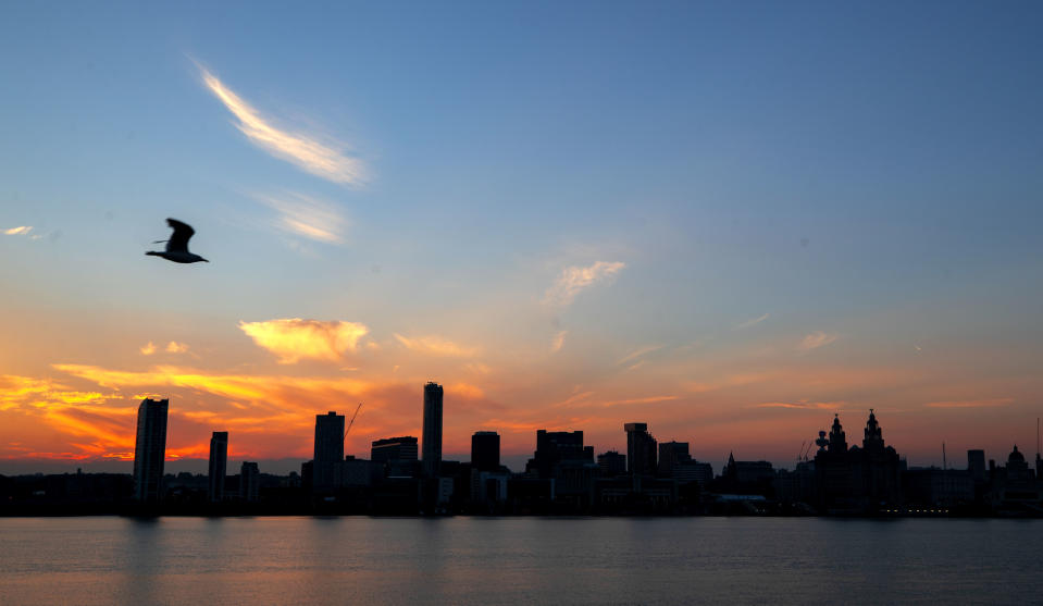 The sun rises behind the Liverpool skyline from Woodside ferry terminal across the River Mersey. Temperatures are expected to hit 35C today as the heatwave continues across the UK.