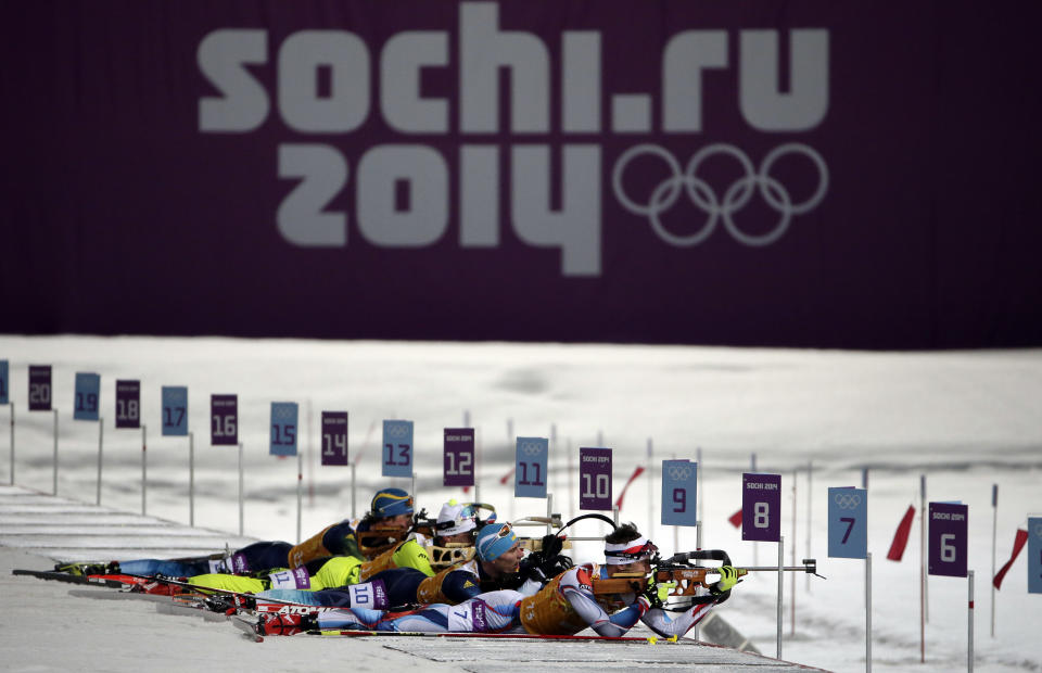 Competitors line up in the shooting range during the men's biathlon 4x7.5K relay at the 2014 Winter Olympics, Saturday, Feb. 22, 2014, in Krasnaya Polyana, Russia. (AP Photo/Felipe Dana)