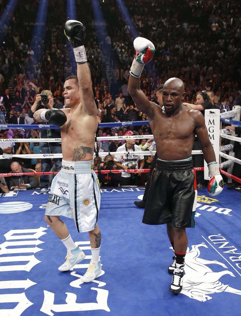 Floyd Mayweather Jr., right, and Marcos Maidana, from Argentina, both react at the end of their WBC-WBA welterweight title boxing fight Saturday, May 3, 2014, in Las Vegas. Mayweather won the bout by majority decision. (AP Photo/Eric Jamison)