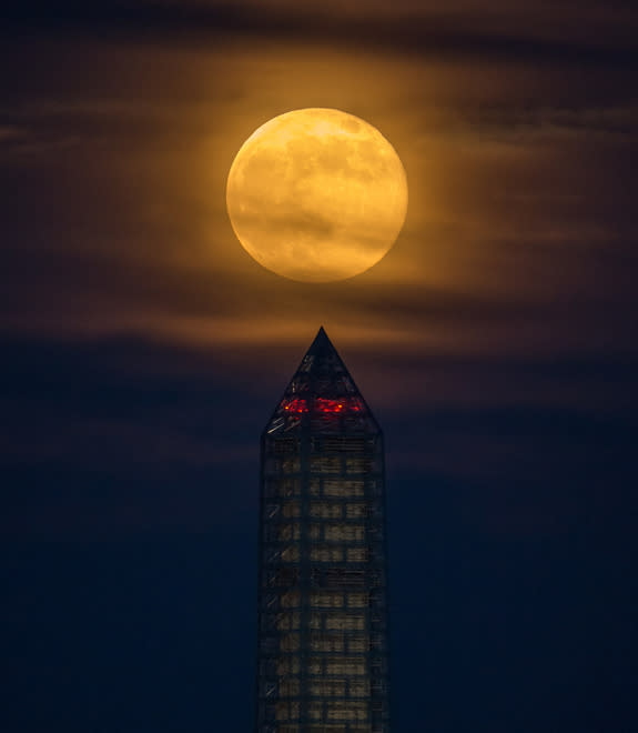 A supermoon climbed its way to the top of the Washington Monument, Sunday, June 23, 2013, in Washington. This year the supermoon is up to 13.5 percent larger and 30 percent brighter than a typical full moon is. This is a result of the moon reac