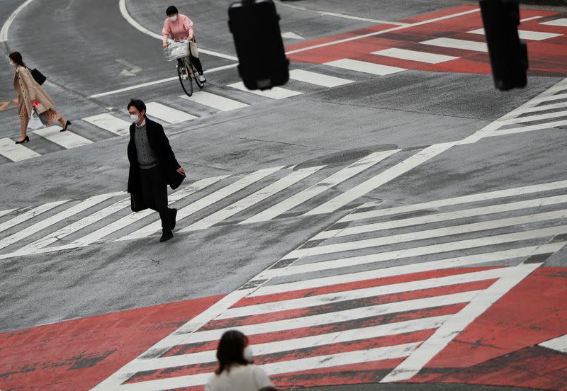 Pedestrians wearing protective face masks, following an outbreak of the coronavirus disease, walk on the crossing at Shibuya shopping and amusement district in Tokyo