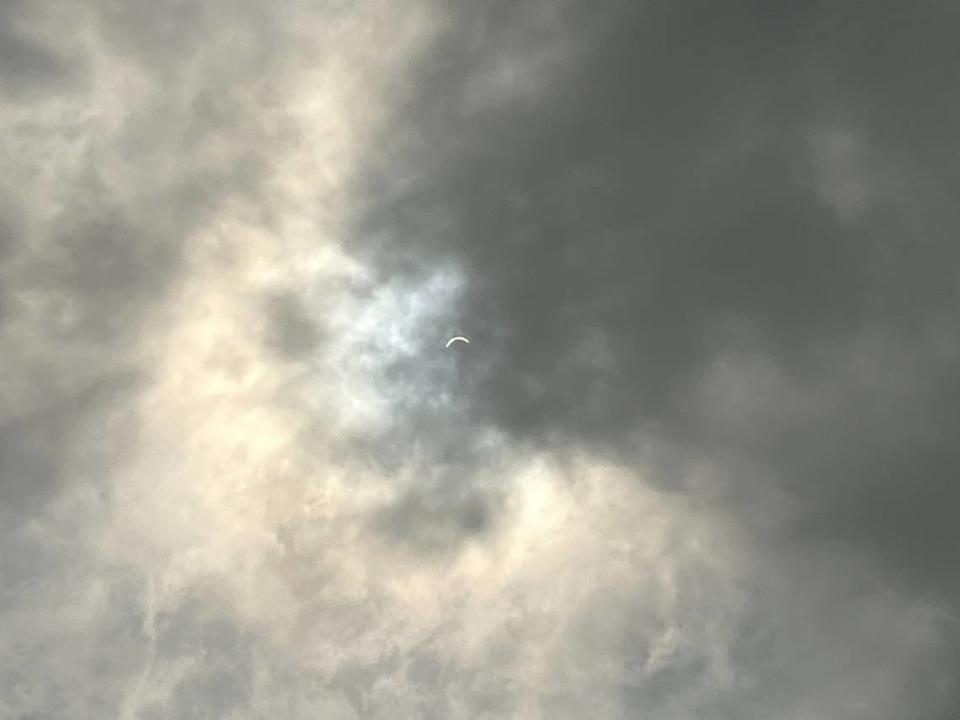 A partially eclipsed sun peaks through a cloudy sky over Lexington, Ky. on April 8, 2024 Diego Espinoza