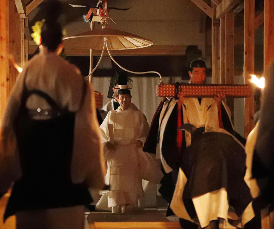 Japan's Emperor Naruhito, center, walks toward Yukiden, one of two main halls of the shrine for Daijosai, or great thanksgiving festival, at the Imperial Palace in Tokyo Thursday, Nov. 14, 2019. Naruhito performed a secretive and controversial ritual Thursday, a once-in-a-reign event to give thanks for good harvests, pray for the peace and safety of the nation and play host to his family’s ancestral gods. (Kyodo News via AP)