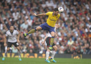 Arsenal's Olivier Giroud gets above Fulham's Scott Parker during the Barclays Premier League match at Craven Cottage, London.