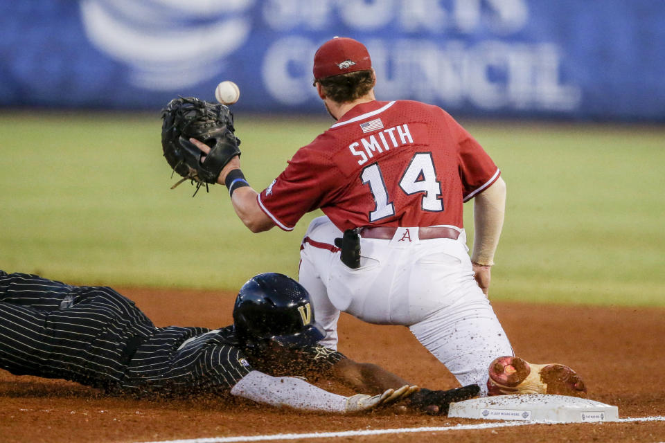 FILE -Vanderbilt's Enrique Bradfield Jr. beats the throw to Arkansas first baseman Cullen Smith (14) as he dives back to first in the first inning of an NCAA college baseball game during the Southeastern Conference tournament Thursday, May 27, 2021, in Hoover, Ala. Bradfield went into Tuesday, May 24, 2022, 42 for 42 stealing bases this season and had swiped 47 in a row since he was caught trying to steal third against Arkansas last May 27. Bradfield's consecutive steals streak is the longest in at least a decade, according to NCAA records. (AP Photo/Butch Dill, File)