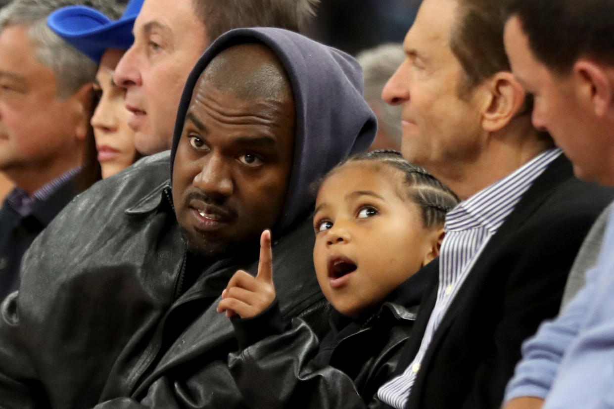 Kanye West, center, and his son, Saint West, got front row seats next to Golden State Warriors co-owners Joe Lacob and Peter Guber as they watch the game against the Boston Celtics in the second quarter at Chase Center in San Francisco, Calif., on Wednesday, March 16, 2022.  (Photo by Ray Chavez/MediaNews Group/The Mercury News via Getty Images)