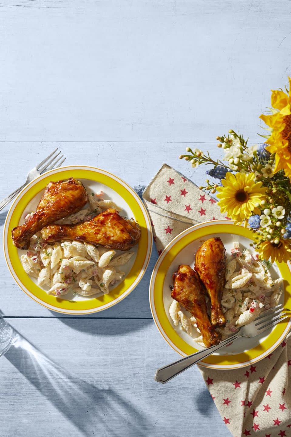 barbecue chicken drumsticks on yellow plate with macaroni salad