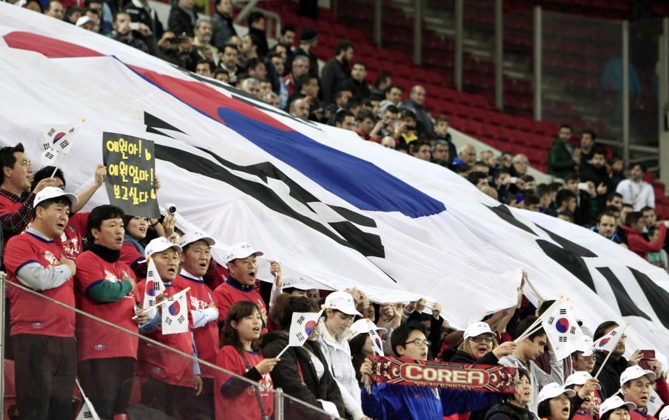 South Korea's fans sing the national anthem of their country during a friendly match against Greece at Georgios Karaiskakis stadium in Piraeus port, near Athens, Wednesday, March 5, 2014. (AP Photo/Thanassis Stavrakis)