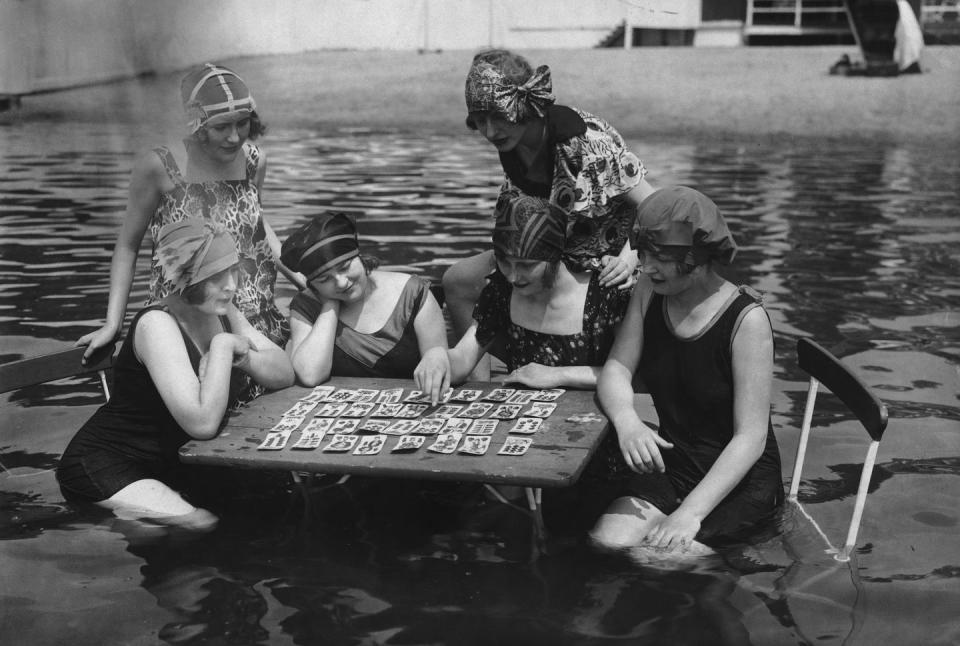 <p>A group of ladies play a card game while they simultaneously cool off in a community swimming pool. It's the best of both worlds.</p>