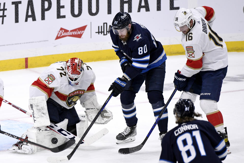 Florida Panthers' goaltender Sergei Bobrovsky (72) makes a save on Winnipeg Jets' Pierre-Luc Dubois (80) during the first period of an NHL hockey game in Winnipeg, Manitoba, Tuesday, Jan. 25, 2022. (Fred Greenslade/The Canadian Press via AP)