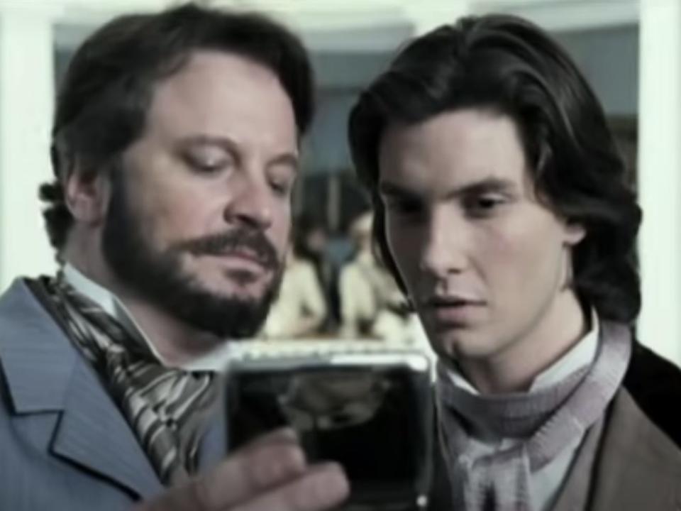 Colin Firth holding up a hand-held mirror to Ben Barnes in "Dorian Gray."