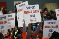 Union members hold up signs during an event in the Queens Museum in New York, Wednesday, Nov. 16, 2022. New York City Mayor Eric Adams was announcing the construction of a new soccer stadium, along with thousands of units of affordable housing, in the dilapidated section of Queens known as Willets Point. (AP Photo/Seth Wenig)
