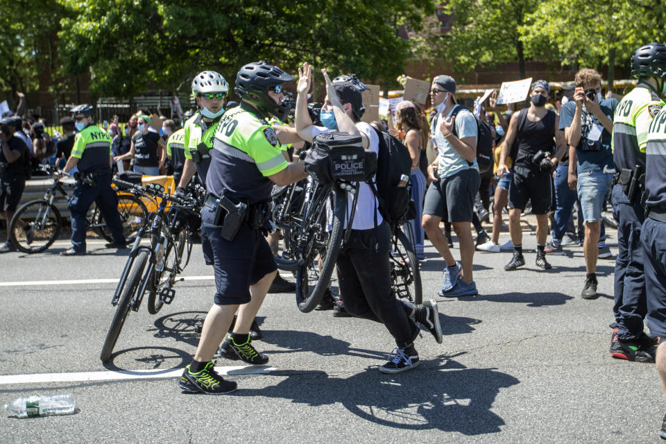 A police officer uses his bicycle to shove a demonstrator during a solidarity rally for George Floyd, Saturday, May 30, 2020, in New York. Floyd died after Minneapolis police officer Derek Chauvin pressed his knee into his neck for several minutes even after he stopped moving and pleading for air. (AP Photo/Mary Altaffer)