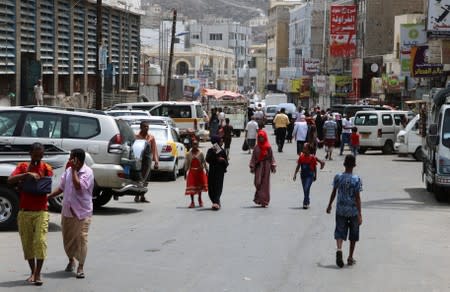 People walk on a street in Aden