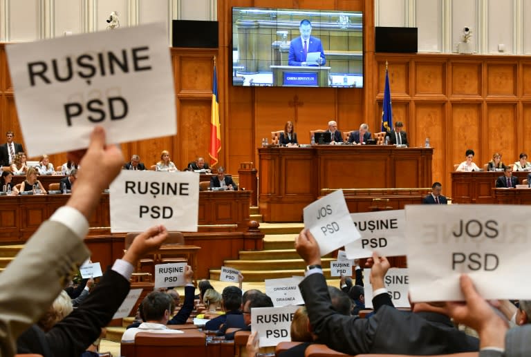 Members Delegates of the opposition hold up posters reading "Shame on PSD" and "Down with PSD" during the ruling party's no-confidence vote in the prime minister