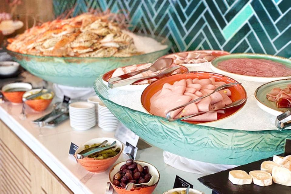 A smörgåsbord of seafood and cold cuts at a hotel buffet.