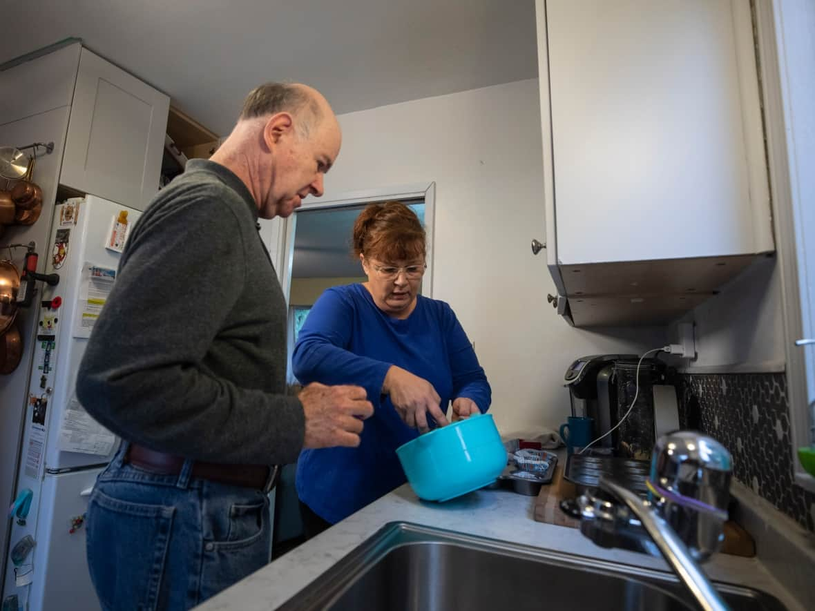 Home-share caregiver Lisa Garner helps her live-in client Paul make his own lunch. (Ben Nelms/CBC - image credit)