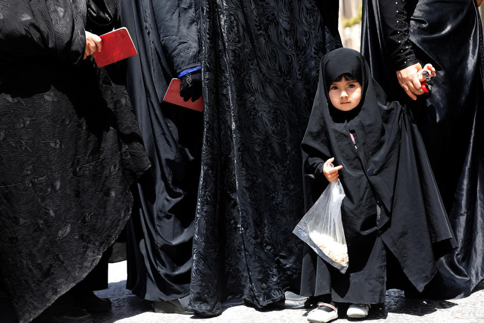 <p>A veiled little Iranian girl stands in a line with her mother among women queing to vote in the Iranian presidential elections at the polling station in the Abdol Azim shrine, in the city of Shahre-Ray, 12 km south of Tehran, Iran, May 19, 2017. Out of the candidates, the race is tightest between frontrunners Iranian current president Hassan Rouhani and conservative presidential candidate Ebrahim Raisi. (Photo: Abedin Taherkenareh/EPA) </p>