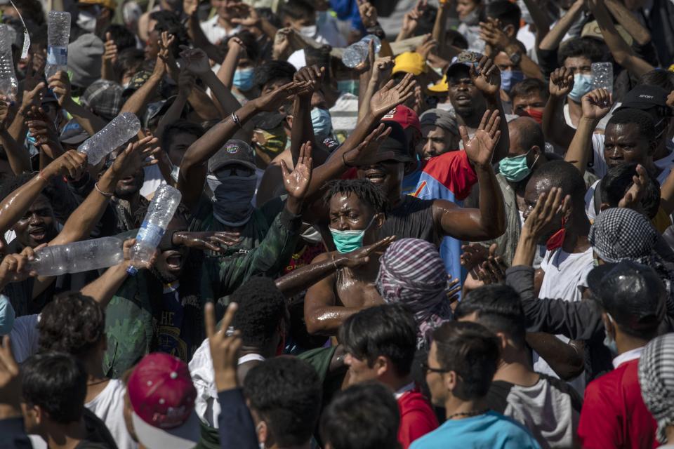 Migrants take part in a rally near Mytilene town, on the northeastern island of Lesbos, Greece, Friday, Sept. 11, 2020. Thousands of protesting refugees and migrants left homeless on the Greek island of Lesbos after fires destroyed the notoriously overcrowded Moria camp have gathered on a road leading to the island's main town, demanding to be allowed to leave. (AP Photo/Petros Giannakouris)