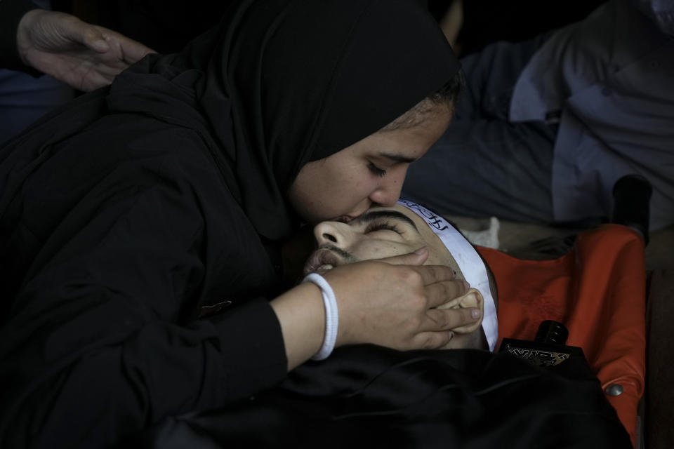 A mourner kisses the body of Palestinian Bara Lahlouh, 24, during his funeral at his family home in the West Bank town of Jenin, Friday, June 17, 2022. Israeli forces shot dead Lahlouh and another two Palestinians and wounded eight others early Friday during a military operation in the occupied West Bank town of Jenin, the Palestinian Health Ministry said. The military said the troops traded fire with militants. (AP Photo/Nasser Nasser)