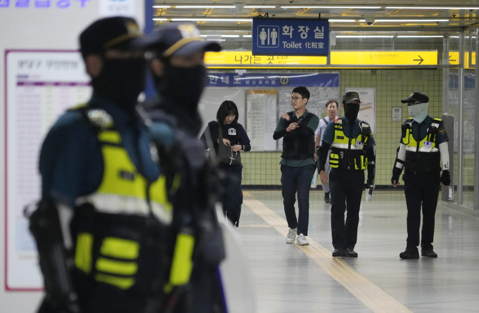 Police officers patrol at Ori subway station following Thursday's attack in Seongnam, South Korea, Friday, Aug. 4, 2023. South Korean police detained a man suspected of stabbing a high school teacher with a knife Friday in the city of Daejeon. The stabbing follows a separate, apparently random attack on Thursday in which 14 people were wounded near a busy subway station in Seongnam. (AP Photo/Ahn Young-joon)