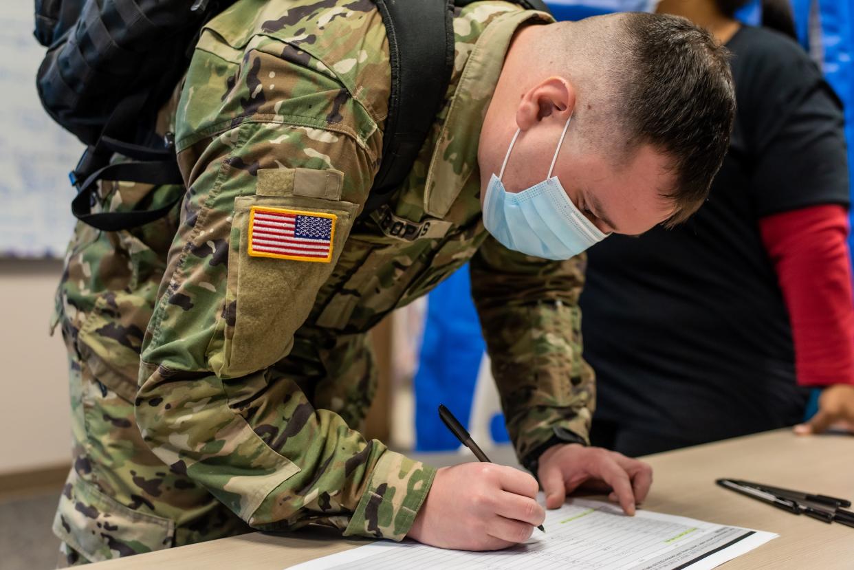 An Ohio National Guard member fills out paperwork after arriving with 69 other troops who arrived at the University of Cincinnati Medical Center on Jan. 24, 2022, to help with the COVID-19 surge.