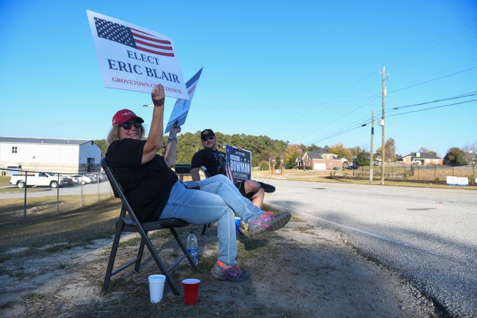 Angel Carr (left) and Alex Cochrane (right) sit outside the entrance to Liberty Park in Grovetown, Ga., on Tuesday, Nov. 7, 2023.