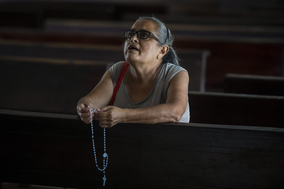 A parishioner prays the rosary as she kneels inside the Cathedral in Matagalpa, Nicaragua, Friday, Aug. 19, 2022. Nicaraguan police on Friday raided the residence of Matagalpa Bishop Rolando Alvarez, detaining him and several other priests in an escalation of tensions between the Catholic Church and the government of Daniel Oretga. (AP Photo/Inti Ocon)