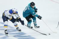May 19, 2019; San Jose, CA, USA; St. Louis Blues center Ivan Barbashev (49) and San Jose Sharks center Joe Pavelski (8) reach for the puck during the second period in Game 5 of the Western Conference Final of the 2019 Stanley Cup Playoffs at SAP Center at San Jose. Mandatory Credit: Darren Yamashita-USA TODAY Sports