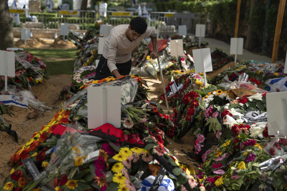 Liyam 20, first name given, pays respect at the grave of his fellow commander, at Mount Herzl military cemetery, in Jerusalem, on Monday, Oct. 16, 2023. (AP Photo/Petros Giannakouris)