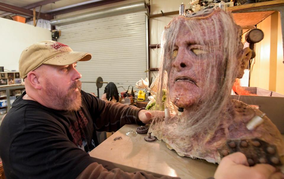 Jonathan Thornton shows off a steampunk Frankenstein mask at his monster studio in Montgomery.