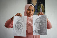 Somali artist Sana Ashraf Sharif Muhsin, 21, displays some of her drawings at her home in the capital Mogadishu, Somalia Friday, Oct. 15, 2021. Among the once-taboo professions emerging from Somalia's decades of conflict and Islamic extremism is the world of arts, and this 21-year-old female painter has faced more opposition than most. (AP Photo/Farah Abdi Warsameh)