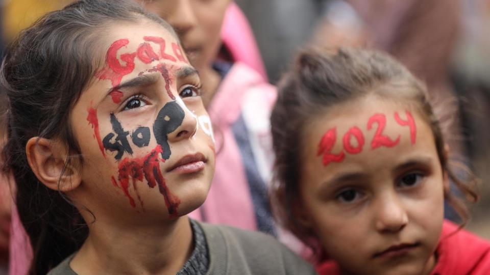 PHOTO: Palestinian artist Menna Allah Hamouda is drawing '2024' on the faces of displaced children ahead of New Year's celebrations at a UNRWA school in Deir Balah in the central Gaza Strip. (Majdi Fathi/NurPhoto via Getty Images)